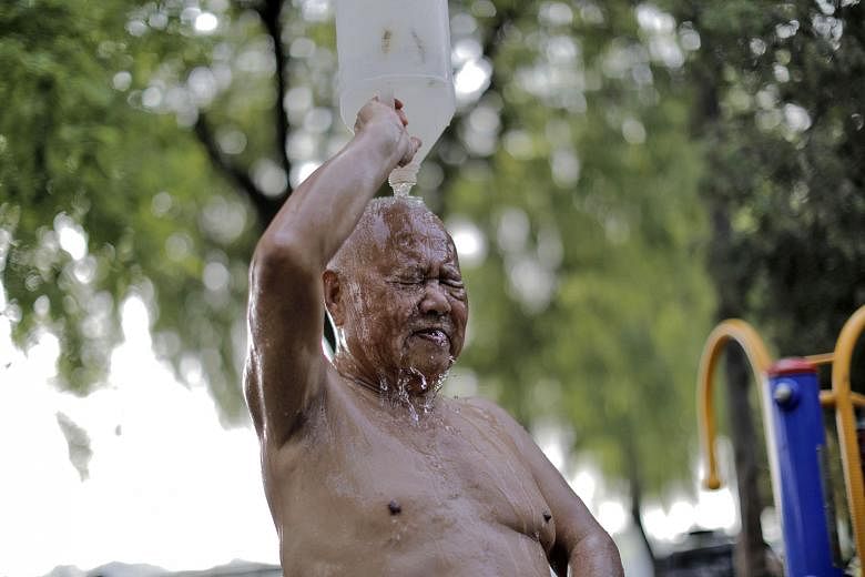 An elderly man splashing himself after a swim in the Houhai lake in Beijing. Residents like him swim in the lake to cool down to avoid heatstroke as temperatures in the Chinese capital soar.