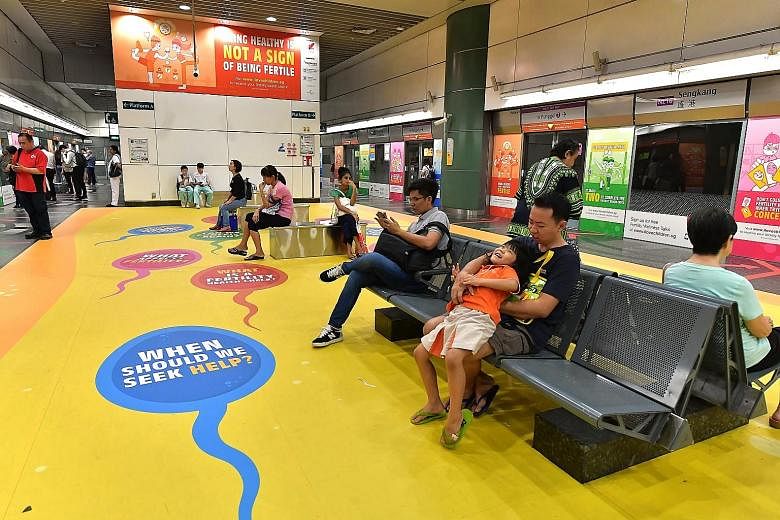 Advertisements at Sengkang MRT station promoting fertility health checks to couples. A new poll of 1,000 respondents found more than half knew someone having difficulty trying for a first or second child, with nearly 70 per cent wrongly thinking that