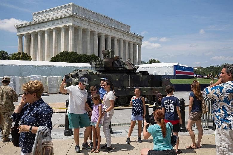 Top: People marching in the Independence Day parade in Washington DC. Above: Members of activist group Code Pink with "Baby Trump" balloons depicting the President in diapers. AGENCE FRANCE-PRESSE People posing in front of a Bradley fighting vehicle 