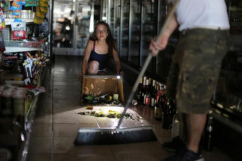 Owners of a liquor store cleaning up after a 6.4-magnitude earthquake struck Southern California on Thursday. PHOTO: REUTERS