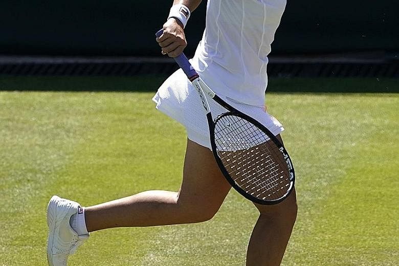Queen of slice Ashleigh Barty returning to Alison van Uytvanck during their Wimbledon second-round match in London on Thursday. The Australian will face Britain's Harriet Dart in the third round today. PHOTO: EPA-EFE