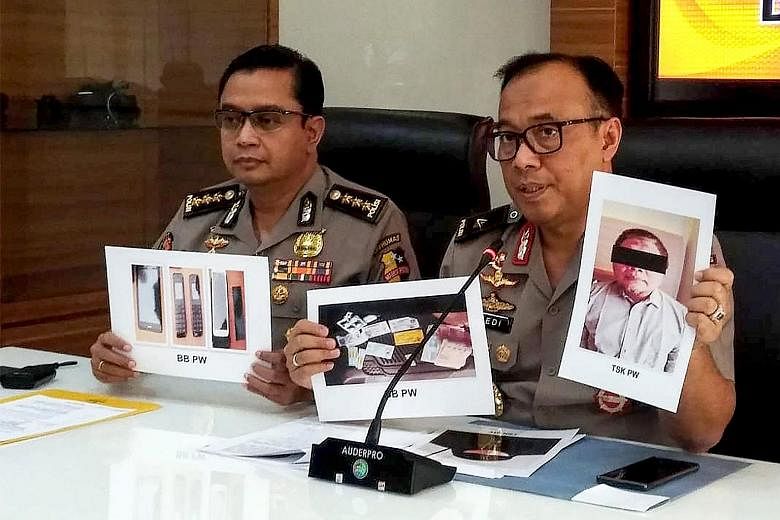Indonesian police with photographs of Neo-JI leader Para Wijayanto and various seized items in Jakarta on Monday. The militant was arrested last Saturday, after 16 years on the run. PHOTO: AGENCE FRANCE-PRESSE