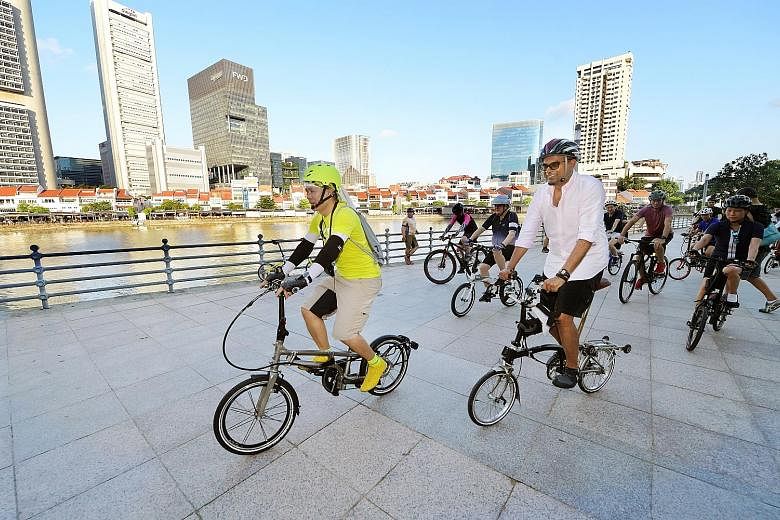 Mr Han Jok Kwang, trustee of The Straits Times School Pocket Money Fund (SPMF), and Dr Janil Puthucheary, Senior Minister of State for Transport and Communications and Information, leading the pack at a charity cycling event yesterday at Marina Bay. 
