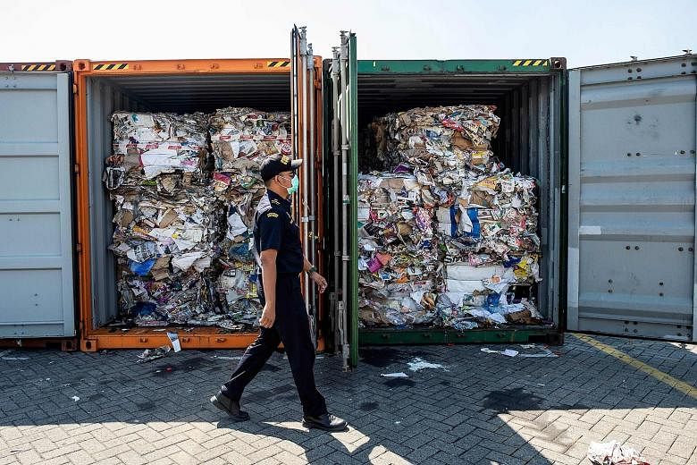 An Indonesian Customs officer inspecting containers filled with garbage at a port in Surabaya, Indonesia, yesterday. The containers from Australia should have contained only waste paper, but the authorities also found other items, including plastic b
