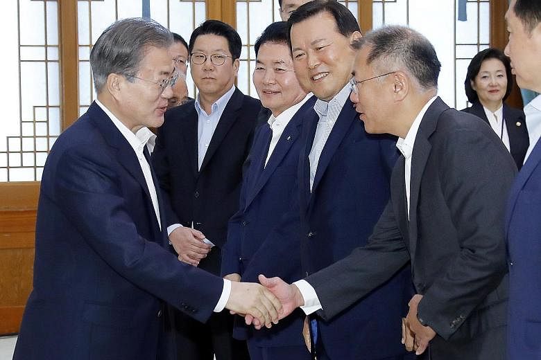 South Korean President Moon Jae-in (far left) shaking hands with Hyundai Motor executive vice-chairman Chung Eui-sun at a meeting with the country's top 30 conglomerates yesterday, where Mr Moon promised to provide active support for domestic product