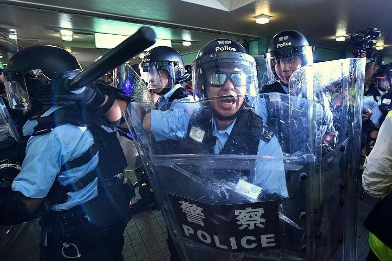 Hong Kong police clashing with black-clad protesters, who marched in Sheung Shui in the New Territories, not far from the Chinese city of Shenzhen, to voice their unhappiness over parallel importers yesterday. Critics say activities by the importers 