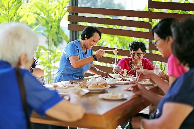 Having overcome her loneliness, Ms Jessie Teo (standing) is now befriending seniors in her neighbourhood through makan sessions, as well as helping those with dementia.