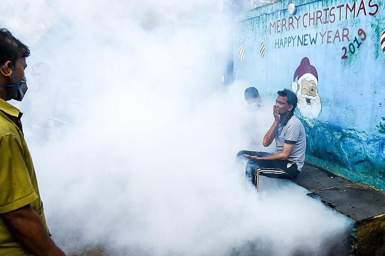 Mumbai residents being engulfed in smoke as municipal employees intensified preventive measures such as anti-malaria fumigation and fogging at a slum in the Indian city yesterday. The authorities have identified areas of the city with mills, railway 