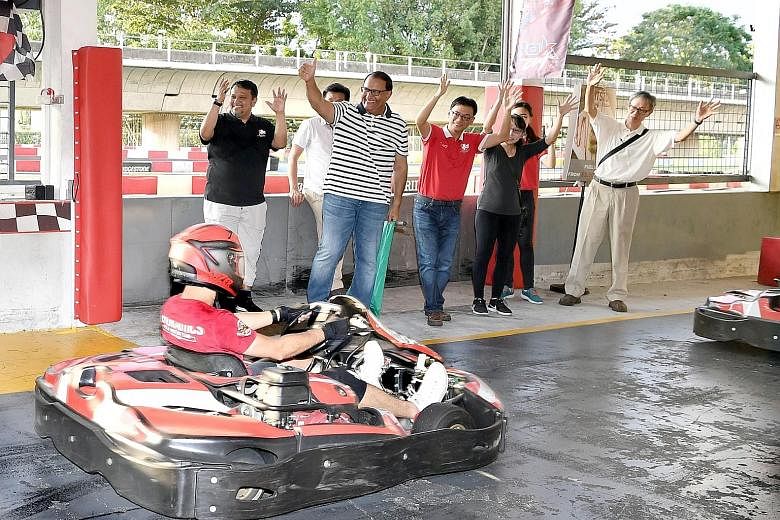 Minister for Communications and Information S. Iswaran (striped t-shirt) flagging off the karting race, one of the National Deaf Games events, at Kranji yesterday. 