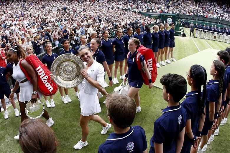 A beaming Simona Halep showing off the winner's Venus Rosewater Dish as she and losing finalist Serena Williams leave Wimbledon's Centre Court after the final yesterday. Halep's 6-2, 6-2 victory made her the first Romanian woman to win the Wimbledon title