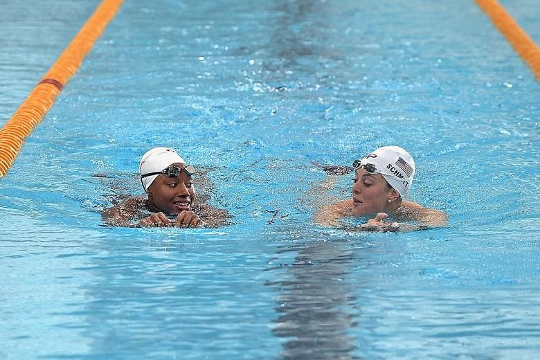 Simone Manuel (left) and teammate Allison Schmitt during the US team training session at the OCBC Aquatic Centre yesterday. 