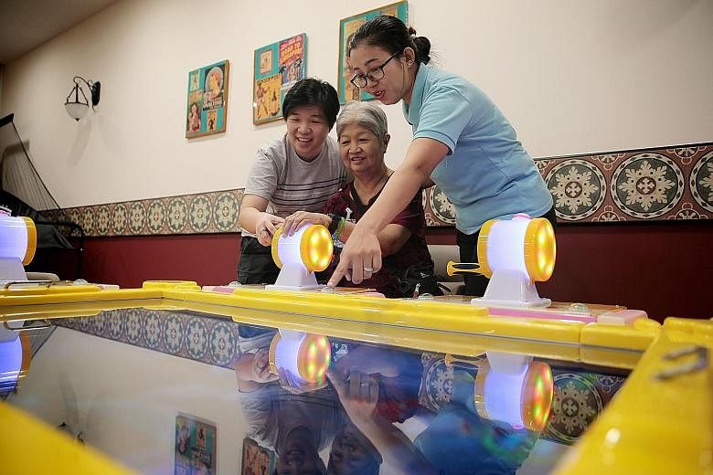 Madam Yong Lee Yoong taking part in a game with her daughter Sally Huang (left) and healthcare assistant Aye Thant Zin at Telok Blangah Senior Care Centre.