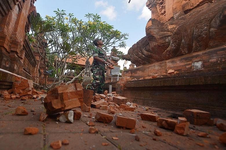 An Indonesian soldier inspecting the damage at a Hindu temple in Bali's capital of Denpasar following a 6.1-magnitude earthquake yesterday. PHOTO: REUTERS