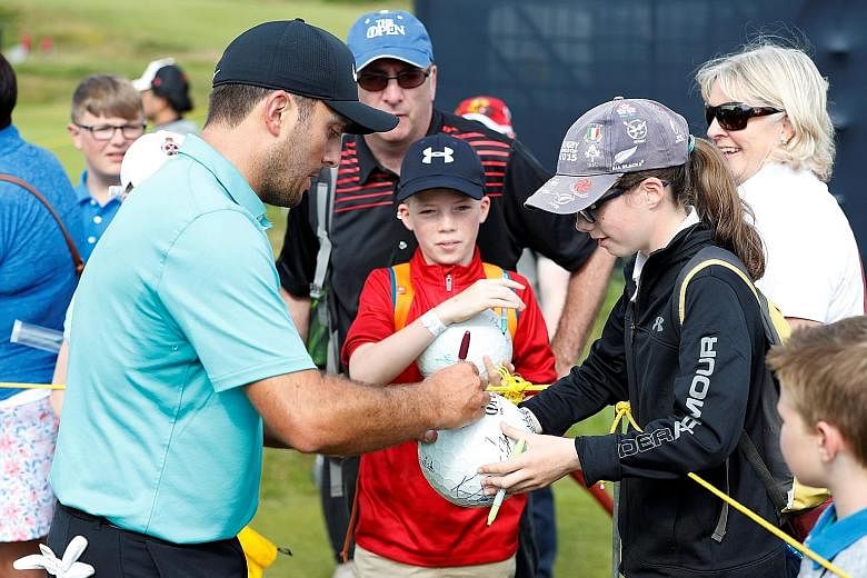 Italy's Francesco Molinari signs autographs during a practice round at Royal Portrush Golf Club in Northern Ireland. The British Open champion will start his defence alongside Bryson DeChambeau and Adam Scott.