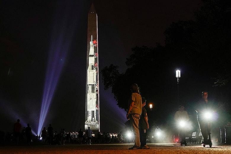 An image of the Saturn V rocket, which launched the Apollo 11 astronauts into space, projected onto a side of the Washington Monument to mark the 50th anniversary of the first lunar mission on Tuesday.