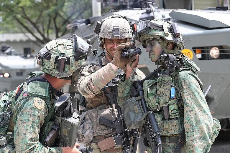 From far left: Singapore Armed Forces (SAF) Third Sergeant Harith Afiq Azman, 23; United States Army Sergeant David T. Mayle, 24; and SAF Lance Corporal Mo Thana Viknesh Waran, 21, at the Murai Urban Training Facility yesterday for Exercise Tiger Bal