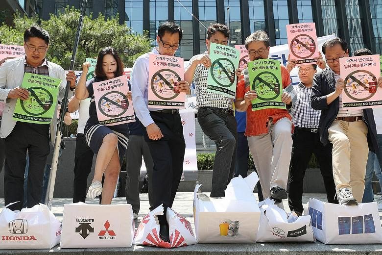 South Korean merchants stepping on boxes bearing logos of Japanese brands during a rally to declare a boycott of Japanese goods in Seoul earlier this month.