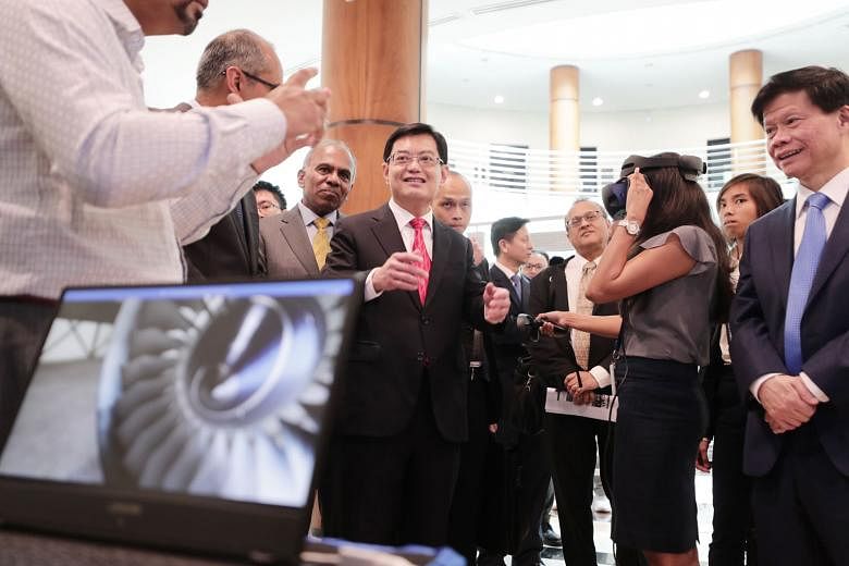 Researchers from the Rolls-Royce@NTU Corporate Laboratory speaking with Deputy Prime Minister Heng Swee Keat about new energy storage solutions that could be used for hybrid-electric aircraft, at the launch of the second phase of the laboratory yeste
