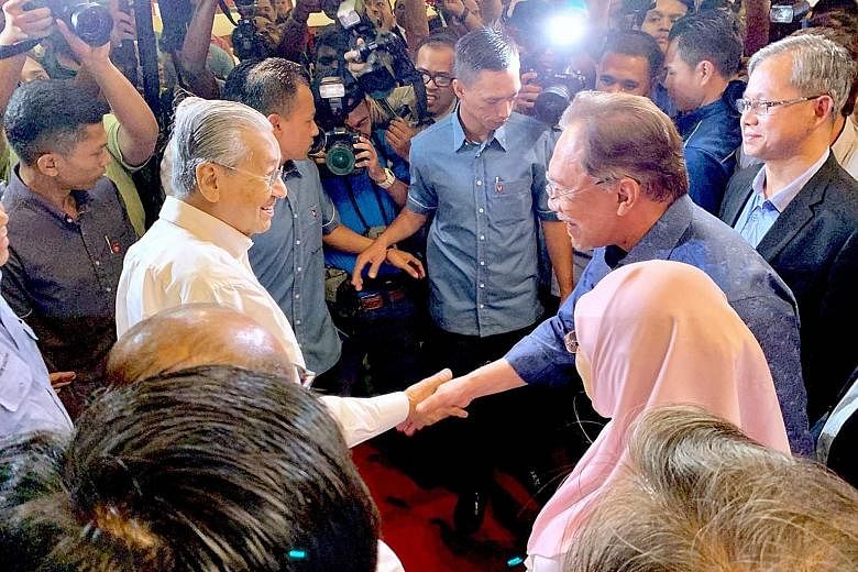 Malaysian Prime Minister Mahathir Mohamad (left) being greeted by Parti Keadilan Rakyat president Anwar Ibrahim on arrival at the party's retreat in Port Dickson yesterday. ST PHOTO: SHANNON TEOH