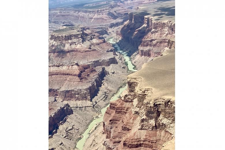 An aerial view of the turquoise Little Colorado River winding through the Grand Canyon.