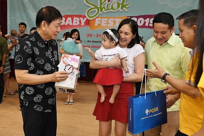 Transport Minister Khaw Boon Wan presenting the top prize in a baby lookalike contest to Madam Venus Bancoro Catibog and her baby Maven Emmanuelle Bancoro Catibog, together with Senior Parliamentary Secretary for Home Affairs and Health Amrin Amin (s