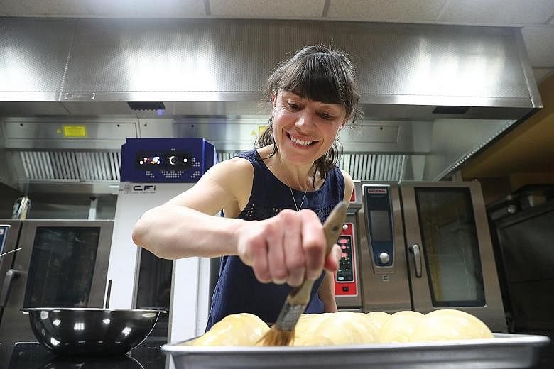 In a test kitchen in Jurong, Ms Kate Reid of Lune Croissanterie, who calls her croissants Yuri, applies egg wash on the pastries using Grug, a pastry brush which only she is allowed to use.
