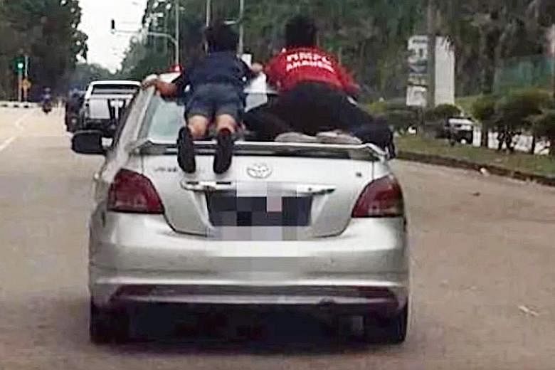 A screengrab from the widely circulated video clip, showing two boys clinging on to a fast-moving car as it speeds down a busy intersection, believed to be in Taman Scientex in Pasir Gudang. The 49-year-old alleged driver of the Toyota Vios was arres