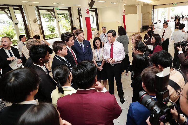 Trade and Industry Minister Chan Chun Sing chatting with students and teachers from 27 schools from across the world yesterday at the opening of the annual Hwa Chong Asia Pacific Young Leaders Summit. The student leaders will visit key institutions h
