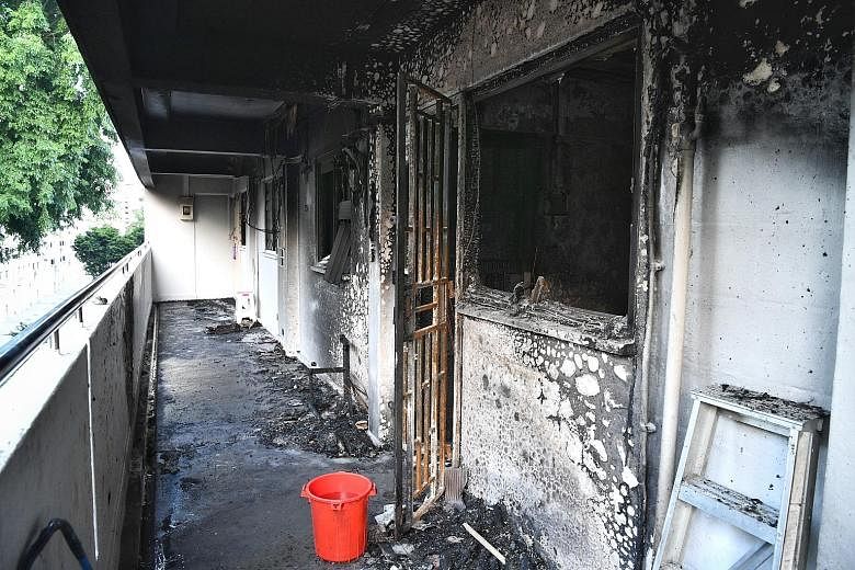 The corridor outside the fourth-floor unit in Block 224 Ang Mo Kio Avenue 1 that was gutted in the fire yesterday. The SCDF rescued one adult and three children from the unit next to the flat. Around 60 people from the block were also evacuated. This