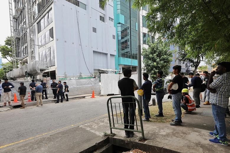 Above: The area where a suspected World War II bomb was found, on the grounds of a half-constructed building in Geylang Lorong 23, was cordoned off after its discovery yesterday. The safety officer of the construction site confirmed that the object w