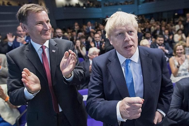 British Foreign Secretary Jeremy Hunt applauding as his rival for the Conservative Party leadership Boris Johnson clinched the vote yesterday. Mr Johnson will succeed Mrs Theresa May as British prime minister, taking over a country in crisis and a go