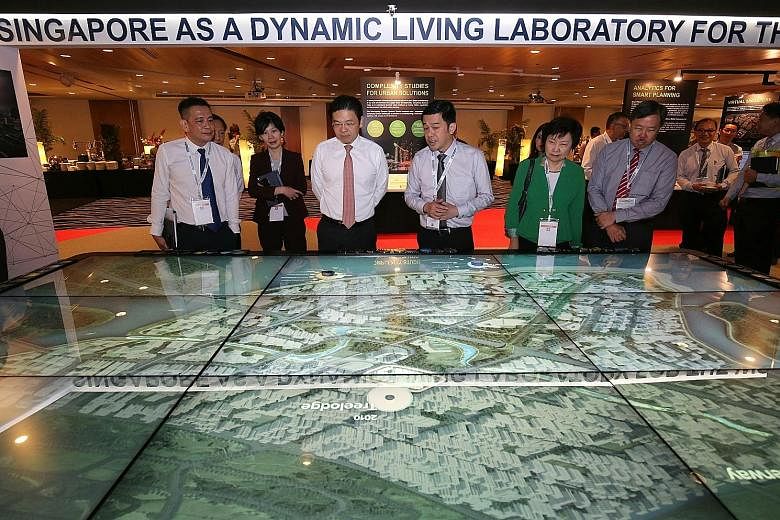 National Development Minister Lawrence Wong (third from left) viewing the Living Laboratory display showcasing living laboratories across Singapore at the Urban Sustainability R&D Congress yesterday. With him were (from left) the Ministry of National