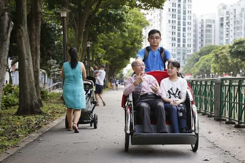 Volunteer Chua Beng Wan giving a ride to retiree Lee Kee Siang and his granddaughter Janet on Oct 8, 2016. ST FILE PHOTO