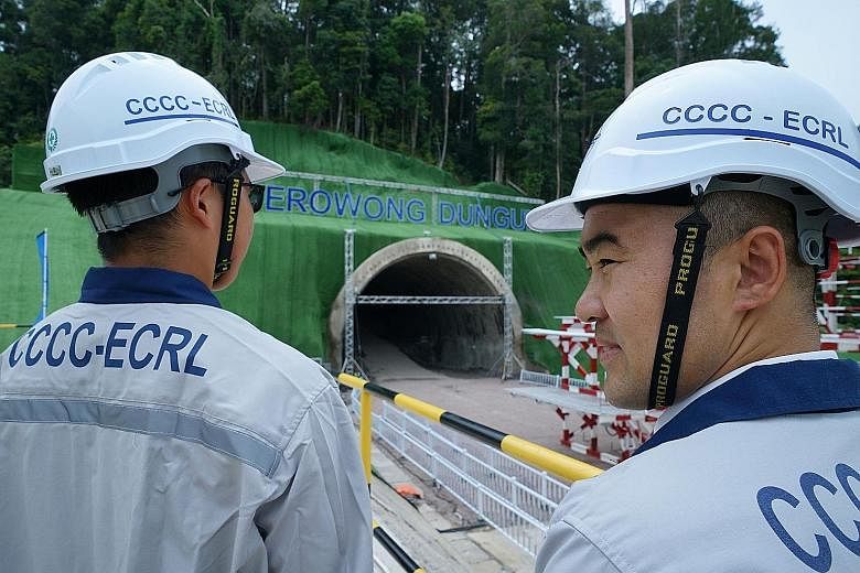 China Communications Construction Company workers standing in front of a tunnel being built for the East Coast Rail Link project in Dungun, Terengganu, yesterday. Malaysia relaunched the project after a year-long suspension and following a deal to sl