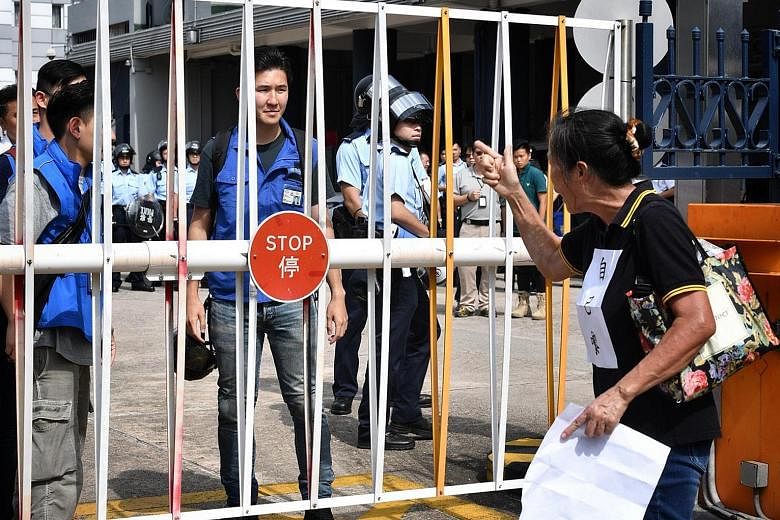 A protester berating police officers during a mass rally in Yuen Long yesterday. Protesters activating their own armed and well-protected squad of demonstrators to meet the riot police that were stationed at the village entrance near Yuen Long MTR st