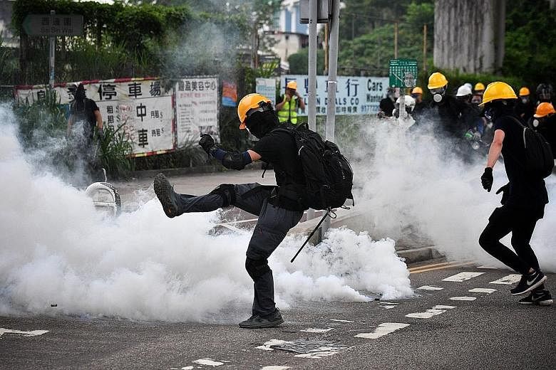 A protester berating police officers during a mass rally in Yuen Long yesterday. Protesters activating their own armed and well-protected squad of demonstrators to meet the riot police that were stationed at the village entrance near Yuen Long MTR st