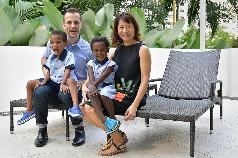 Spoka's Mr David Grainger with his wife Kirsty Leong, who is global policy officer of World Wildlife Fund for Nature, and their two children adopted from Ethiopia, Remi (left), four, and Wegeny, three. Money, to Mr Grainger, means options and a sprin