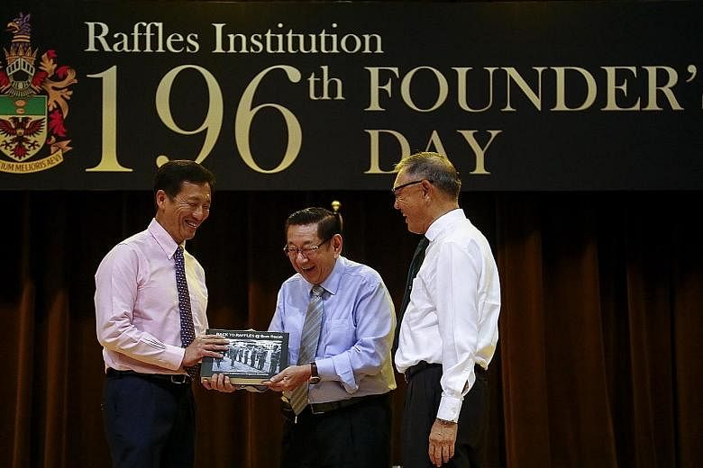 Education Minister Ong Ye Kung being presented the book Back To Raffles @ Bras Basah by Raffles Institution alumnus Er Kwong Wah. Beside them is RI board of governors chairman Choo Chiau Beng.