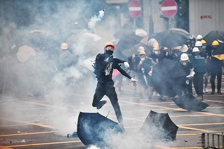 Black-clad protesters fought street battles with riot police in Hong Kong yesterday during a protest in retaliation for an attack by suspected triad gangs on activists and commuters last Sunday. Defying a police ban, thousands of protesters gathered 