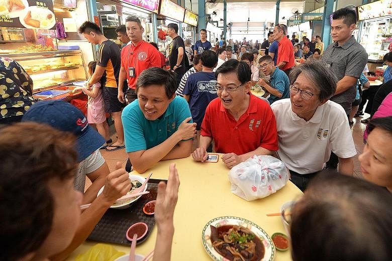 Deputy Prime Minister Heng Swee Keat, flanked by Minister for Trade and Industry Chan Chun Sing (left) and East Coast GRC MP Lim Swee Say, chatting with residents during a ministerial walkabout at The Marketplace @ 58 yesterday. It was the 40th such 
