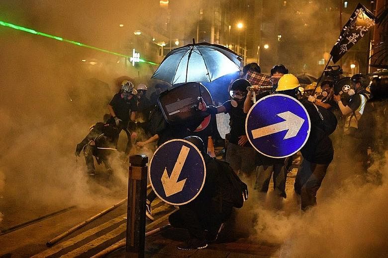 Riot police firing tear gas to disperse protesters taking part in a rally in Hong Kong yesterday, in the eighth straight weekend of protests to oppose a controversial extradition Bill. PHOTO: EPA-EFE