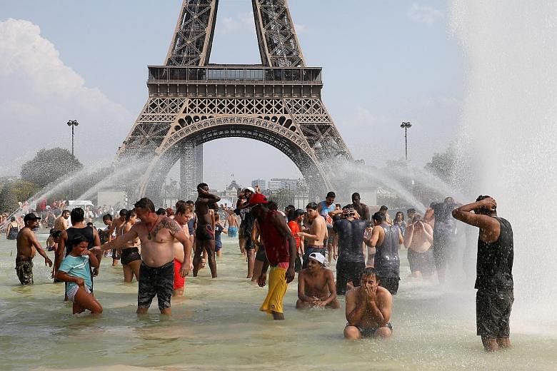 People cooling off in the Trocadero fountains across from the Eiffel Tower in Paris as a new heatwave broke temperature records in France last Thursday. PHOTO: REUTERS