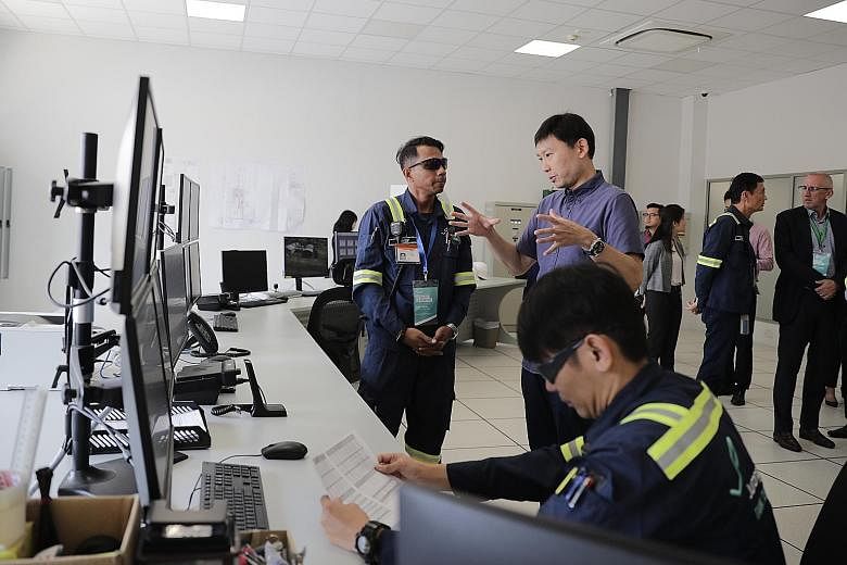Senior Minister of State for Trade and Industry Chee Hong Tat with Jurong Port Tank Terminals shift leader Yusoff Khan in the central control room of the newly opened port yesterday.