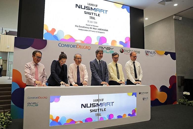 Above: The electric shuttle will operate between Heng Mui Keng Terrace and Business Link at 20-minute intervals on weekdays. The service, which is free of charge, will not operate when it rains. Below: At the launch of the shuttle trial at NUS yester