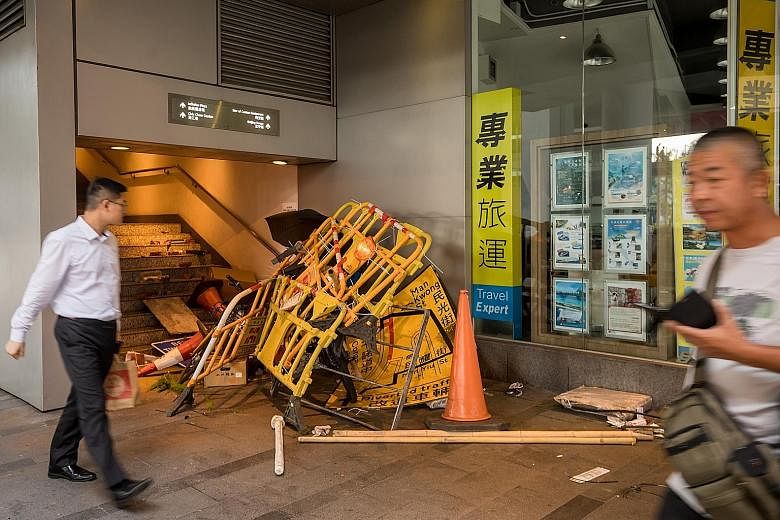 Barriers and other street objects used by demonstrators at the bottom of a pedestrian overpass yesterday morning, after clashes between protesters and the police in the Sheung Wan area on Sunday. PHOTO: BLOOMBERG