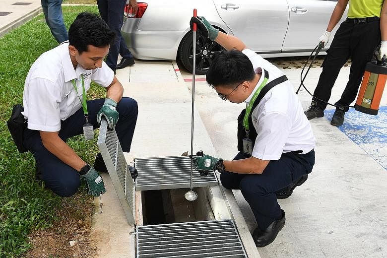 Officers from the National Environment Agency checking for mosquito larvae in Woodlands. As of July 20, nine people in Singapore, including a 46-year-old man, have died from dengue this year. ST PHOTO: KHALID BABA
