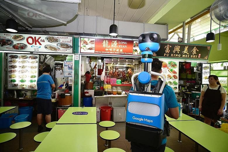 Street View Trekker operator Keith Lee, 24, capturing indoor imagery at Dunman Food Centre yesterday. All 114 hawker centres here will have their individual stalls marked with separate pins on the Google Maps app by early next year, showing their exa