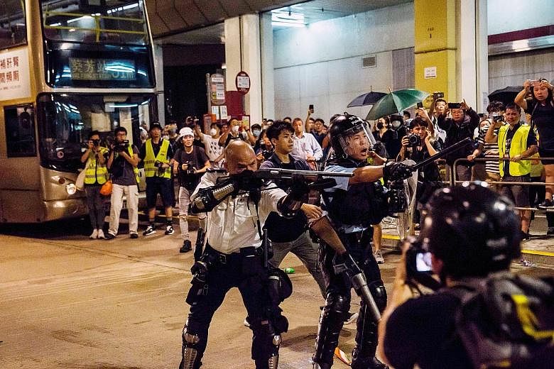 Police officers in a clash with protesters outside the Kwai Chung Police Station last night. They used pepper spray and batons in a bid to disperse the protesters. PHOTO: AGENCE FRANCE-PRESSE