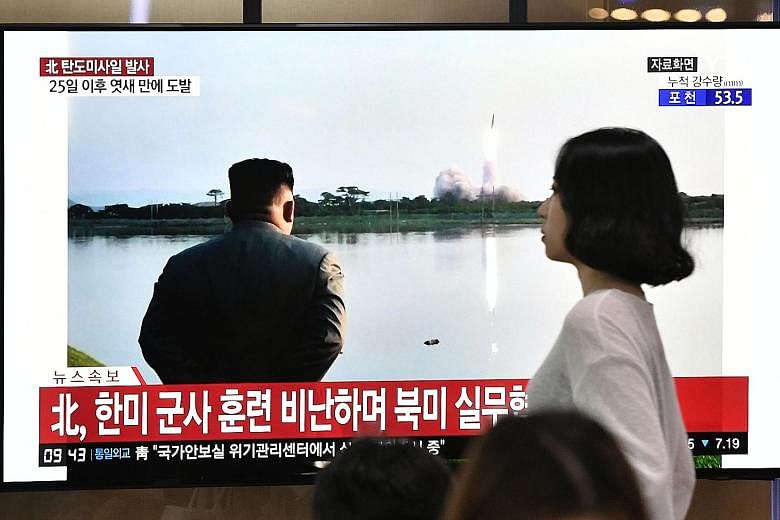 A television set at a railway station in Seoul yesterday broadcasting file footage of North Korean leader Kim Jong-un watching a missile launch.