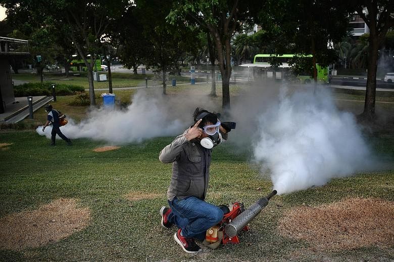 PUB contractors carrying out fogging around Pandan Reservoir yesterday evening. ST PHOTO: ARIFFIN JAMAR